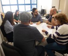 Imagem horizontal colorida em que se vê a equipe do CENSE em reunião com a equipe da DPE-PR.