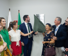 Momento do descerramento da placa de inauguração, com defensores públicos e autoridades reunidos ao redor, aplaudindo o marco da nova sede.