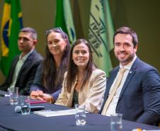 Imagem em que se vê as autoridades da DPE-PR sentadas à mesa, ao fundo as bandeiras do Paraná e do Brasil.