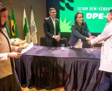 Servidor cumprimenta a autoridades na mesa da cerimônia de posse. 