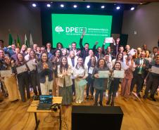 Servidores posam juntos no placo para foto ao fim da cerimônia. 
