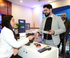 Mulher sentada apresenta serviços de tecnologia para homem com barba de terno em pé. 