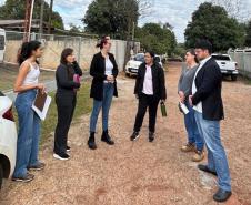 Equipe do NUFURB discute estratégias antes da atuação no território. Seis pessoas conversam em uma rua de barro. 
