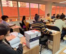 Imagem mostra sala de aula pouco antes do início da prova da segunda fase do quinto concurso para defensoras e defensores públicos do Estado do Paraná. 