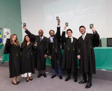Novos defensores públicos posam com suas carteiras funcionais ao final da cerimônia de posse. 