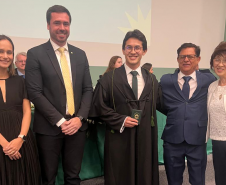 Novo defensor público empossado posa ao lado de representantes da instituição e familiares. 
