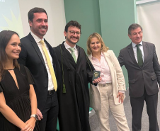 Novo defensor público empossado posa ao lado de representantes da instituição e familiares. 