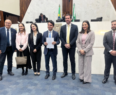 Imagem com a foto de representantes da Defensoria na Assembléia Legislativa do Paraná, junto do deputado Alezandre Curi, para entrega de projeto de Lei