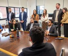 Grupo de pessoas, homens e mulheres, acompanham a reunião hibrida presencial e online em que foi realizada a votação e apuração dos votos para Defensor Público Geral do Paraná. 