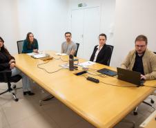 Equipe da captação de recursos sentados a uma mesa de reuniões.