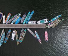 Imagem aérea mostra barcos vistos de cima no pier de Guaraqueçaba.