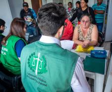 Defensor Público aparece de costas realizando atendimento para uma mulher em Guaraqueçaba. 