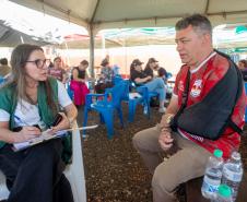 Assistente social da Defensoria Pública realiza atendimento de homem com torniquete no braço vítima do tornado em Rio Bonito do Iguaçu. 