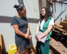 Psicóloga da Defensoria Pública realiza escuta qualificada de uma mulher vítima do tornado em Rio Bonito do Iguaçu. O cenário da conversa é a casa destruída pelo vento. 