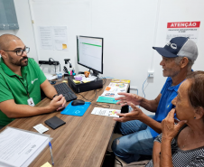 Servidor da DPE-PR atendendo casal de idosos durante mutirão do Concilia em Guaíra.