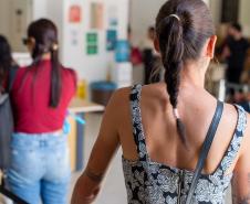 Imagem mostra mulher de costas entrando na sede da Defensoria.