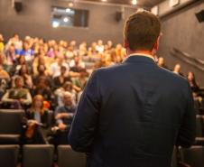 Público acompanha fala antes do início da apresentação.