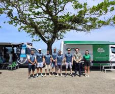 Equipe da Defensoria Pública do Paraná posa em frente à Van de Direitos durante a Operação Verão Maior em Matinhos. 