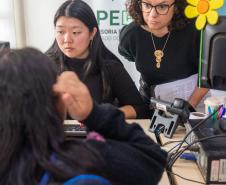 Imagem mostra servidoras da DPE-PR realizando atendimento em um CRAS em Cascavel durante mutirão da DPE-PR.