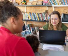 Imagem mostra Defensora Pública realizando atendimento de uma mulher na comunidade 29 de Março em Curitiba durante mutirão. 
