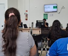 Imagem mostra duas mulher de costas aguardando na fila para recebem atendimento durante o Mutirão da Defensoria em Maringá.