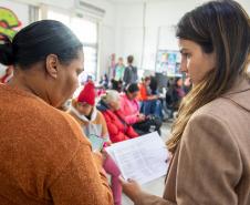 Imagem mostra Defensora Pública conversando com uma assistida durante mutirão de atendimentos da DPE-PR.