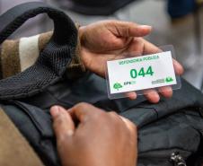 Detalhe mostra senha de atendimento na mão de assistido da DPE-PR.