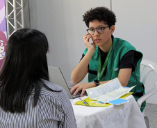 Servidora da DPE-PR realiza atendimento de uma mulher durante Mutirão em Maringá.  