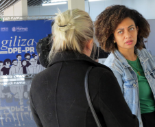 Imagem mostra servidora recepcionando uma assistida na entrada do Mutirão.  