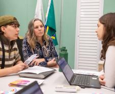Homem trans acompanhado da mãe recebe atendimento em Mutirão da Defensoria Pública do Paraná.