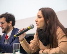 Ana Carolina Pinto fala ao microfone. Ela é Promotora de Justiça do Ministério Público do Estado do Paraná.