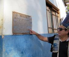 Cacique mostra a placa comemorativa à instalação do telefone público na comunidade.