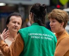 Psicóloga da Defensoria Pública conversa com senhoras idosas em trabalho de orientação na Boca Maldita, em Curitiba.