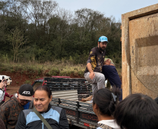 Grupo distribui telhas e lonas em caminhão. 