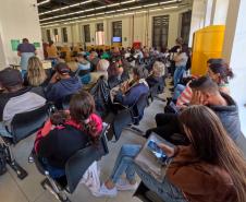 Imagem mostra aala de espera da Sede Central da Defensoria Pública com grande número de assistidos aguardando atendimento. 