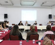 Na imagem vemos  os Assistentes Sociais participantes do evento sentados em mesas distribuídas em forma de roda, debatendo.