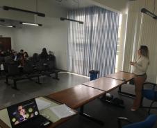 Na imagem vemos a Dra. Luciana Tramujas falando para o público presente. 