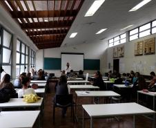 Em frente ao quadro, dra. Olenka Lins fala com os alunos que acompanham sua explicação.