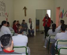 Dra. Cinthia Azevedo Santos está palestrando, no fundo de uma sala, na penitenciária feminina. 