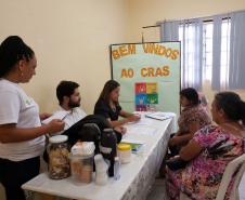Na imagem vemos alguns defensores públicos sentados a uma mesa conversando com assistidos. 
