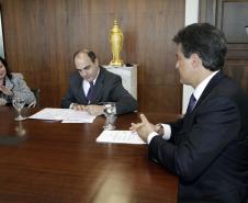 O presidente da Cohapar, Mounir Chaowiche, assina o convênio.