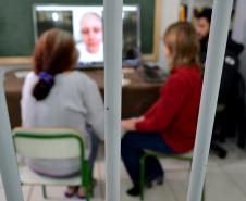 Detenta assiste a vídeo com depoimento de familiares durante encontro com equipe técnica da Defensoria Pública do Paraná.