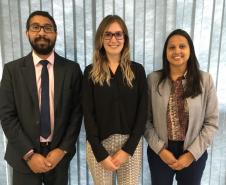 Estão na foto, da esquerda para a direita: o defensor público auxiliar do Núcleo Wisley Rodrigo dos Santos,  a defensora pública de Direitos Humanos da Regional Paraná/ Santa Catarina, Carolina Balbinott Bunhak e a coordenadora do Núcleo da Cidadania e Direitos Humanos da Defensoria Pública do Paraná (NUCIDH) Cinthia Azevedo Santos. Os três estão olhando para a lente da câmera.  