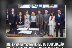 Foto mostra oito pessoas lado a lado e em frente a uma mesa. Na imagem, um título onde se lê: Defensoria assina Termo de Cooperação para retomar projeto de atendimento a vítimas de crimes
