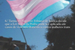 Na imagem, uma bandeira do movimento trans e uma manchate onde se lê: 6.ª Turma do Superior Tribunal de Justiça decide que Lei Maria da Penha pode ser aplicada em casos de violência doméstica contra mulheres trans 
