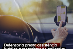 Imagem mostra uma pessoa dentro de um carro, mexendo em um aplicativo no celular 