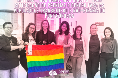 Imagem que mostra diversas pessoas da equipe que trabalhou no mutirão segurando uma bandeira LGBT com as cores do arco-íris. Acima das pessoas, está escrito o título da matéria “Mutirão Meu Nome, Meu Direito leva retificação de prenome e gênero para as populações transgênero e não-binária de Ponta Grossa”.