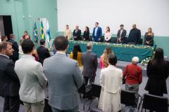 Imagem horizontal colorida onde se vê o público em primeiro plano e ao fundo a mesa de representantes da instituição que conduziram a cerimônia de posse dos novos Defensores Públicos do Paraná. 