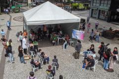 Imagem horizontal colorida feita de drone em que aparece a tenda montada na Boca Maldita e as pessoas aguardando o atendimento para o Mutirão da DPE-PR.