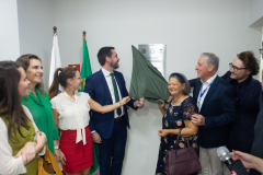 Momento do descerramento da placa de inauguração, com defensores públicos e autoridades reunidos ao redor, aplaudindo o marco da nova sede.